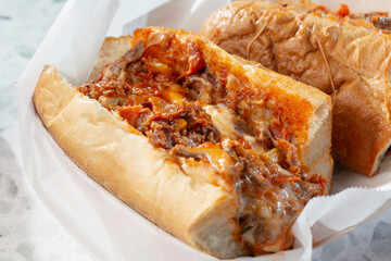 A closeup view of a pizza cheesesteak sandwich.