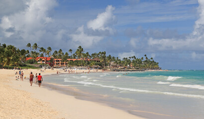 Beautiful beach in Punta Cana with turquoise water and hotels resort on the background, Dominican Republic