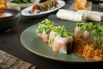 A closeup view of a sushi roll, featuring spicy albacore and yellowtail, among other Japanese entrees.