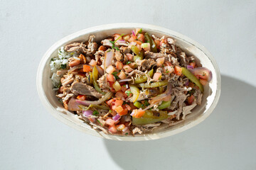 A top down view of a restaurant style carnitas burrito bowl.