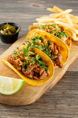 A view of a wood board of carne asada tacos.