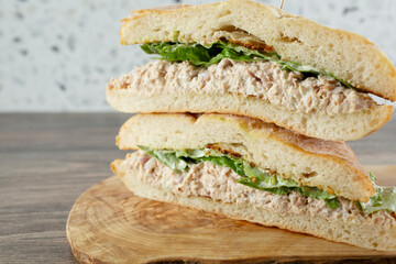 A view of a tuna sandwich stack on a wood board.