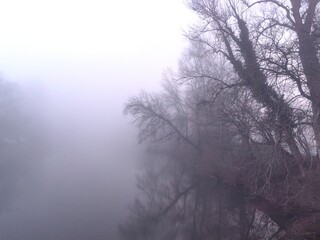 Winter landscape on foggy river. Poor visibility on the river due to fog