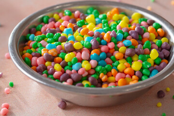 A closeup view of a metal condiment cup of rock candy.