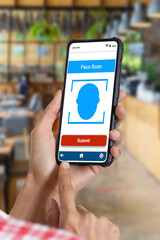 Hand holding smartphone showing face scan application on screen.