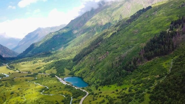 Aerial drone view of mountain landscape glaciers and valley on a sunny day. Dombay, North Caucasus, Karachay-Cherkessia. High quality 4k footage