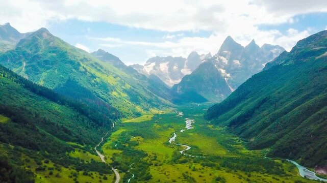 Aerial drone view of mountain landscape glaciers and valley on a sunny day. Dombay, North Caucasus, Karachay-Cherkessia. High quality 4k footage