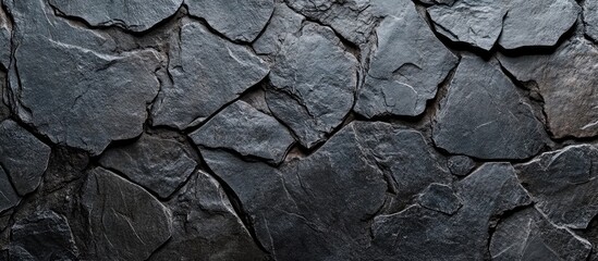 Fototapeta premium Abstract dark grey stone wall texture with rough surface and empty copyspace for text ideal for backgrounds and design layouts.