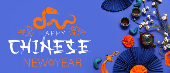 Teapot with cups of tea, flower branch and different Chinese symbols on blue background. New Year...