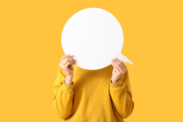 Young woman with blank speech bubble on yellow background