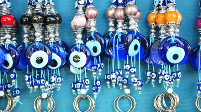 a bunch of blue evil eye keychains hanging on a shelf