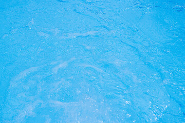 Serene blue water surface with gentle ripples and a soft sun glow