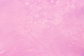 Calm, pink water surface with subtle waves and a dreamy, ethereal quality