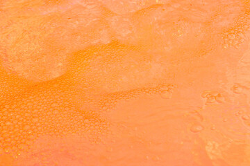 Energetic orange liquid with foamy bubbles. Perfect for summer and tropical themes
