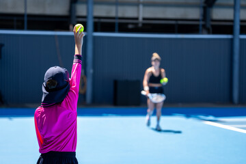 Ball kids collecting tennis balls for professional tennis players in a tournament wearing hats...