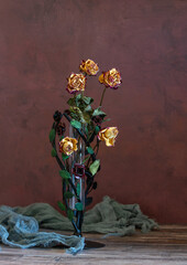A small bouquet of dried roses on a dark background.