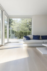 Obraz premium Modern living room with large windows and natural light in a serene environment