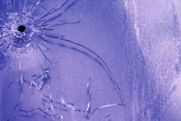 Bullet hole is in double pane of glass. Web of cracks, old web of spider debris is stirring in...