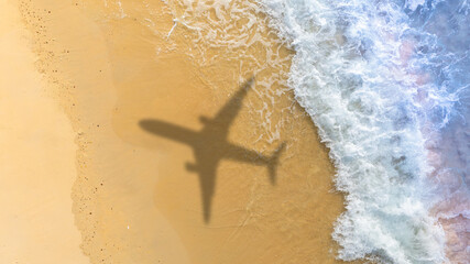 Aerial view of shadow passenger plane silhouette and sandy beach  blue sea with waves at sea beach summer vacation sea travel concept