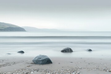 Minimalist beach with smooth stones and gentle waves under soft light