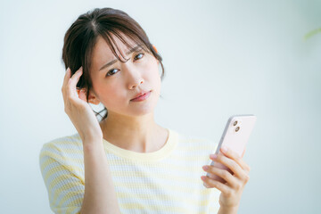 Fototapeta premium 部屋でスマホを操作する女性