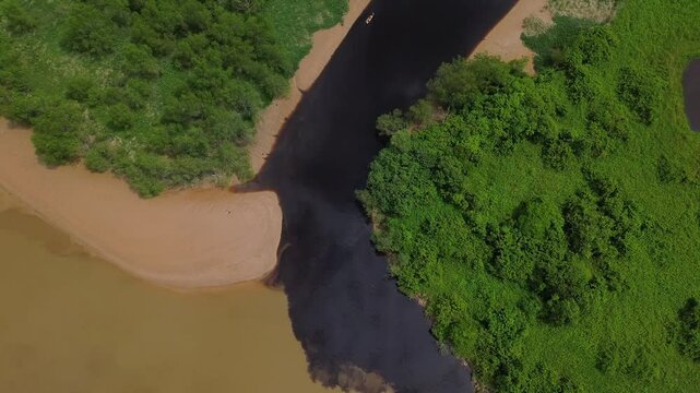 A mesmerising aerial view of a dark coloured river flow into low tide Batang Rajang in Sibu, Malaysi