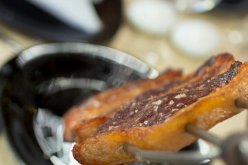 Juicy picanha skewer with crispy golden fat and coarse sea salt, high angle view close-up.