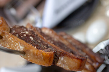 Brazilian picanha skewer with crispy golden fat and sea salt, close-up.