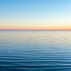 A smooth, calm ocean surface with soft ripples and light blue water, reflecting a pastel sky with a faint hint of the sun setting in the distance, ideal for serene and peaceful designs.