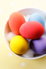 Happy Easter eggs in a bowl on dot yellow color background.