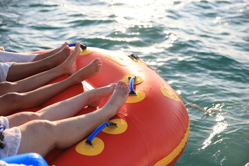 Family's  legs resting on an inflatable on a yacht while sailing on the sea