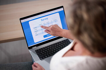 Woman Looking At Online Survey Laptop Computer