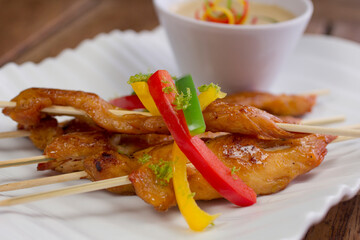 Delicious glazed chicken skewers topped with vibrant bell peppers, served with a creamy spicy...