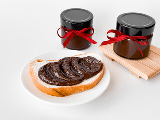 Luxury chocolate spread on bread with elegant ribboned jars in minimalist setting