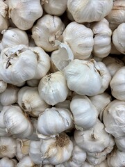 Closeup on white bulbs of garlic in bin at grocery store