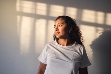 Young woman enjoying the sun rays in the home at sunset