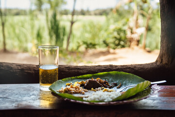 traditional Sri Lankan meal served on a leaf with a beer
