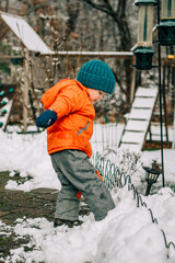 Fototapeta premium Child stepping into snow by fence