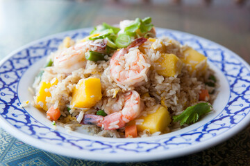 A mango, rice, and shrimp dish sits on a table at a Thai restaurant.