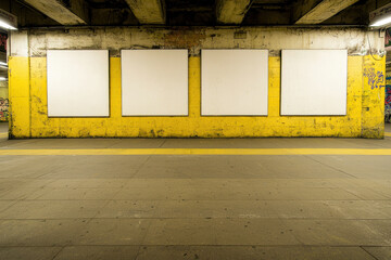 Empty subway station wall with yellow paint and blank frames