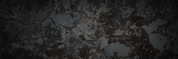 Texture of the old wall. Rough grungy surface of painted plastered concrete wall with spots, cracks, noise and grain. Dark wide panoramic background for design. Shaded vintage texture with vignette.