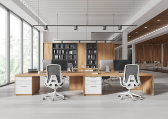 Modern coworking office interior with large wooden desks, ergonomic chairs, and natural light from floor-to-ceiling windows. 3D Rendering