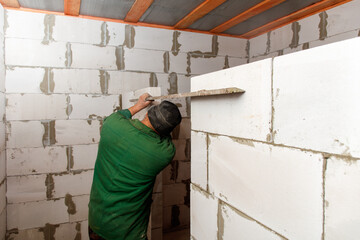 A man is working on a wall with a trowel