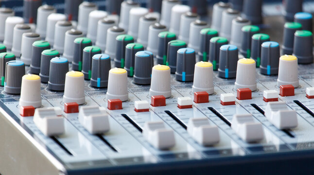A mixing board with many knobs and buttons