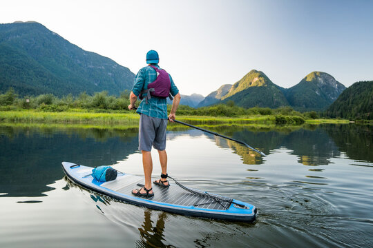 Rear view of man exploring river on paddle board