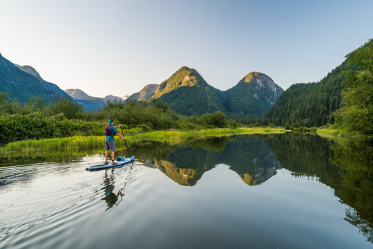 Paddle boarding in pristine nature reserve, scenic mountain view