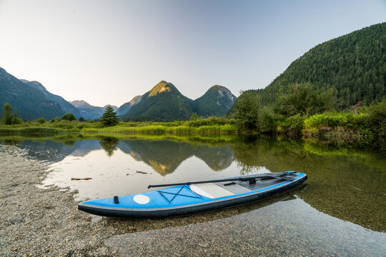 Paddle Board pulled up on remote beach, scenic view of mountains