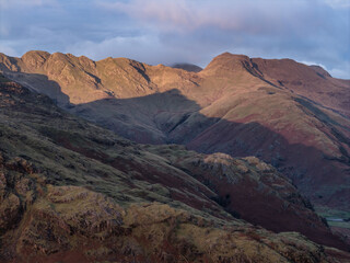 Beautiful aerial drone landscape image of Blea Tarn and Langdale Valley in Lake District during vibrant Autumn sunrise