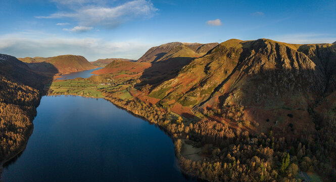 Dramatic aerial drone landscape in Autumn Winter of snowcapped mountains around Buttermere in Lake District at sunrise