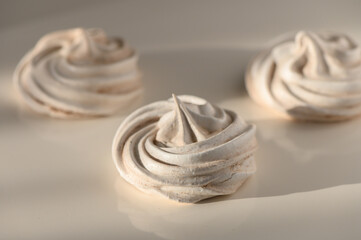 Delicate swirls of meringue artfully arranged on a soft, neutral background for culinary delight